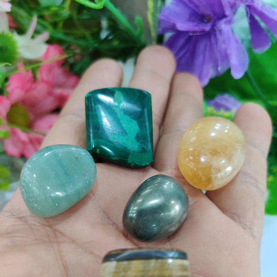 Assortment of raw lucky crystals including Aventurine, Citrine, Pyrite, Tiger\'s Eye, Jade, and Rose Quartz